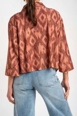 Kimono de viscosa color cobre con estampado geométrico abstracto en tonos marrones y destellos metalizados, de mangas 3/4 y diseño fluido y abierto.