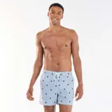 Short de baño con diseño de rayas verticales blancas y celestes, decorado con pequeños estampados de tortugas en color azul marino. Cuenta con cintura elástica y cordón ajustable blanco.