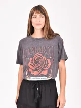 Remera de manga corta, corte holgado y efecto gastado (acid wash) en color gris oscuro. Estampado frontal con una rosa roja, estrellas y el texto "ROCK & ROLL" y "make some noise".