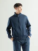 Campera de estilo deportivo en color azul marino, con cierre frontal completo, cuello alto y bolsillos laterales. Presenta un diseño minimalista con logo bordado sutil en el pecho.