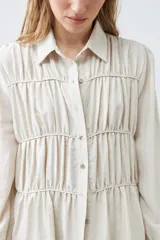 Camisa beige melange con frunces en el frente, de manga larga y cuello camisero.