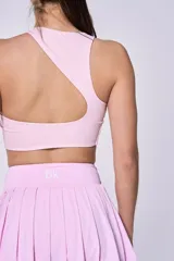 Conjunto deportivo compuesto por un top de cuello redondo y una pollera tableada con cintura alta, ambos en color rosa pastel.