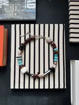 Collar de piedras y cuentas artesanales multicolor, con eslabones metálicos y cierre ajustable.