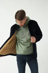 Chaqueta marrón de pana con cuello clásico, cierre frontal con botones, bolsillos con solapa abotonados en el pecho y bolsillos laterales. Interior capitoneado en azul.