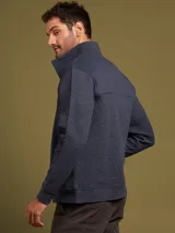 Sweater azul marino con cuello alto abotonado, diseño acolchado y bolsillo tipo canguro.