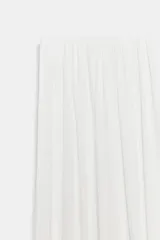 Pantalón de tiro medio confeccionado en tejido satinado blanco, con cintura elástica, diseño plisado y bajo abullonado y asimétrico.