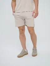 Bermuda Umbro de hombre, color beige, confeccionada en tejido de algodón con bolsillos laterales y cintura elástica con cordón de ajuste.