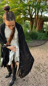 Ruana tejida a mano en lana merino 100%, color verde militar, con diseño de puntos calados y flecos largos en el ruedo.