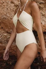 Malla enteriza blanca con diseño cut out en la parte delantera, escote halter con fruncido y tiras multiposición.