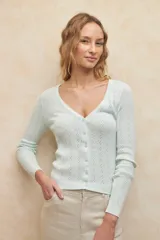 Cárdigan corto color verde agua, de tejido tramado y corte ajustado.