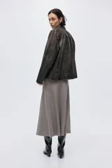 Pollera midi de corte evasé confeccionada en tejido de punto fino, con cintura elástica y costuras verticales visibles tanto en el frente como en la parte posterior.