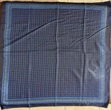 Pañuelo de seda negro con estampado de lunares celestes y un marco ornamental con detalles en tonos azules y blancos.