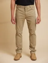 Pantalón de jean color beige, de corte recto y tiro medio.