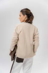 Saco básico de punto color marfil, confeccionado en lambswool, con corte entallado tipo chaquetita. Destaca por detalles de blonda tejida en los puños y a lo largo de la abertura frontal, con bordes en color contrastante.
