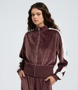 Campera deportiva de plush color bordó, con cuello alto, cierre frontal y rayas laterales blancas en las mangas. Presenta puños y ruedo acanalados.