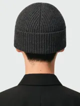 Gorro tipo beanie de punto acanalado en color gris oscuro, con el logo de corazón característico de Ami Paris bordado en rojo en la parte frontal.