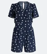 Mono corto azul marino con estampado de lunares blancos, escote en pico, mangas cortas abullonadas, elástico en la cintura, bolsillos laterales y cierre en forma de gota en la espalda.