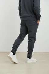 Pantalón jogging de corte ajustado, con cintura elástica y puños elastizados en los tobillos. Presenta un diseño minimalista en color gris oscuro, ideal para un look urbano y deportivo.
