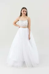 Vestido largo de tul color blanco, con escote bordado y falda con volados.