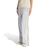 Pantalón deportivo Adidas modelo W Sta Seas Pt para mujer, de tejido de malla color gris con tiras laterales a rayas y botones a presión. Cuenta con cintura elástica con cordón de ajuste y logo de la marca bordado.