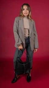 Blazer a cuadros color beige, con solapas de muesca, cierre frontal con botón y bolsillos laterales.