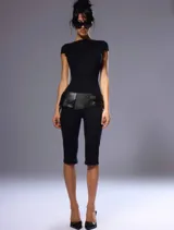 Mono capri negro de manga corta, con escote cerrado redondo al frente y espalda descubierta, confeccionado en tejido elástico.