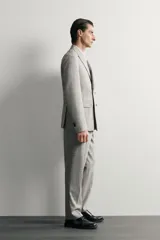 Blazer regular fit de Zara, confeccionada en tejido con mezcla de lana y algodón con diseño de cuadros grises. Cuenta con solapas de pico, doble botonadura cruzada, bolsillos con solapa en la cadera y bolsillo de vivo en el pecho.