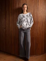 Buzo de punto gris con estampado de tigres en color negro, cuello redondo y mangas largas con puños acanalados.