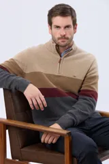 Buzo tejido de punto con diseño de rayas horizontales en tonos verde, gris y azul. Presenta cuello alto con cierre frontal parcial y detalle en material tipo gamuza en la solapa del cierre.