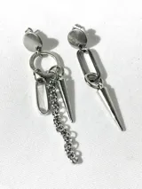 Par de aros colgantes asimétricos de acero quirúrgico plateado. Uno presenta un círculo, un eslabón rectangular, una cadena y un dije en forma de cono. El otro presenta un eslabón rectangular y un dije en forma de cono.