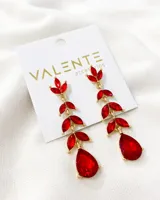 Aros colgantes dorados con forma de rama y hojas de cristal rojo.