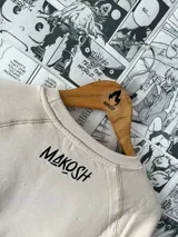 Buzo color beige con estampado de corazón tribal y personajes de anime.