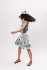 Vestido tejido a rayas verticales en tonos celeste y gris, sin mangas, con cuello redondo y corte recto. Incluye cinturón tejido con flecos.