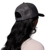 Gorro tipo trucker con frente de algodón negro y paneles traseros de malla gris. Presenta un parche frontal rectangular con diseño de montañas y el logo de la marca.