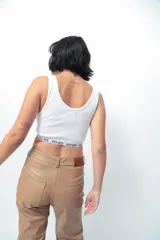 Top corto de morley color blanco, con escote redondo y elástico personalizado con el nombre de la marca en el bajo busto.