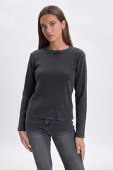 Remera de manga larga confeccionada en tejido rib con efecto lavado, cuello redondo y corte recto.