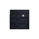 Chaleco puffer Moncler modelo Tibb de color azul marino, con diseño acolchado horizontal, cuello alto y cierre frontal con cremallera y botones a presión. Cuenta con bolsillos laterales y el parche distintivo de la marca en el pecho.