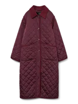 Campera larga de estilo acolchado en color bordó, con cuello camisero de pana, cierre frontal con botones y dos bolsillos delanteros amplios. Presenta un diseño de rombos característico del tejido matelassé.