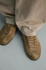 Zapatilla de hombre confeccionada en piel con acabado en serraje, color marrón, con cordones al tono y suela ultrafina.