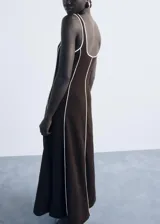 Vestido midi de algodón color marrón con diseño de rayas verticales en relieve de color blanco. Presenta cuello escotado, tirantes anchos y un corte recto.