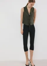 Camisa sin mangas de lino y algodón color verde militar, con cuello solapa y cierre frontal con múltiples lazos.