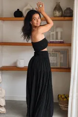 Conjunto de dos piezas negro con hilos de lurex plateados, compuesto por un top strapless fruncido y una falda larga de corte fluido.