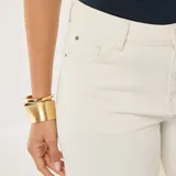 Jean de corte wide leg en color blanco, con diseño de cinco bolsillos y cierre frontal con botón y cremallera.