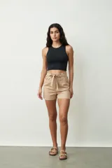 Short de tiro alto con estampado botánico en tonos verdes y crudos. Presenta una cintura elástica con lazo ajustable del mismo tejido, bolsillos laterales y un corte holgado.