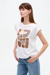 Remera de algodón blanca de manga corta, corte holgado y cuello redondo. Cuenta con un estampado frontal abstracto con detalles metalizados en tono cobre.