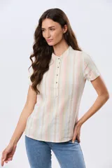 Camisa de lino de manga corta con cuello mao y cierre frontal parcial con botones. Presenta un diseño de rayas verticales en tonos suaves como rosa, verde, celeste y beige.