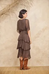 Vestido midi color rosa pálido, con escote en V, mangas cortas y corte escalonado con volados.