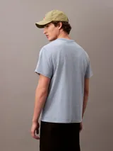 Remera de manga corta celeste con logo Calvin Klein Jeans bordado en amarillo en el centro del pecho.
