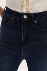 Jean de tiro alto, color azul oscuro, con calce ajustado hasta la rodilla y abertura ancha estilo oxford/flare.