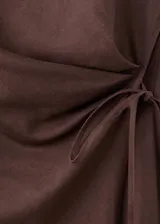 Vestido midi cruzado de color marrón, confeccionado en mezcla de lino y algodón, con cuello redondo, sin mangas y lazo ajustable en la cintura.
